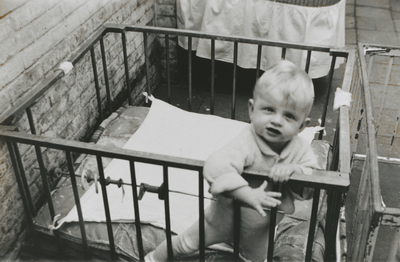 876982 Afbeelding van een jongetje in een box op de binnenplaats van het opvanghuis 'Meisjesstad' (Oudegracht 35) aan ...